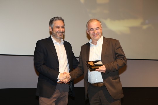 Βραβείο Κοινού Fischer_ Ελληνική παραγωγή άνω των 45’: Ο Γιάννη Κατσούγκρης Υπεύθυνος Χορηγιών Αθηναϊκής Ζυθοποιίας απονέμει το βραβείο στον Νίκο Ασλανίδη, σκηνοθέτη της ταινίας «Παράδοξη Πατρίδα»