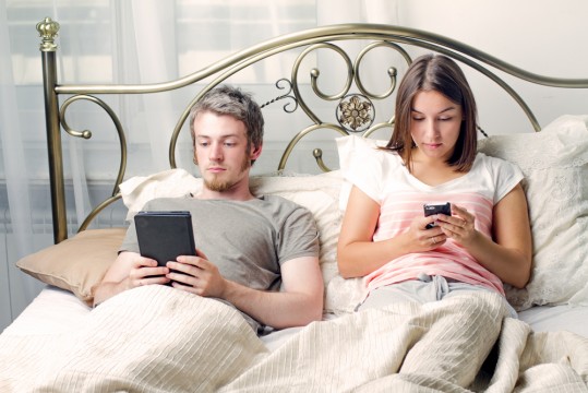 couple-in-bed-with-phones
