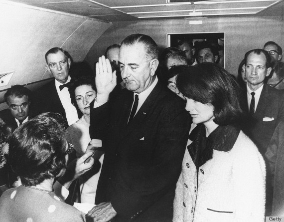 Flanked by Jackie Kennedy (right) and his wife Lady Bird Johnson (second left), U.S Vice President Lyndon Johnson (center) is administred the oath of office by Federal Judge Sarah T. Hughes (left) as he assumed the presidency following the assassination of President John F. Kennedy in Dallas, Texas, November 22, 1963. (Photo by CECIL STOUGHTON/AFP/Getty Images)